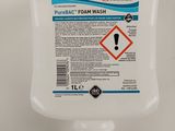 un gros plan d'un distributeur de savon pour les mains posé sur une surface blanche