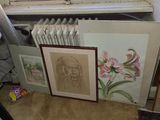 many framed pictures of flowers on the floor next to a radiator
