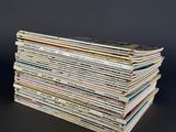 a stack of magazines sitting on a table with a black background