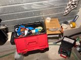 a red box with tools in it sitting on the floor