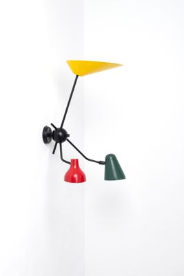 two colorful lamps are hanging on a wall next to a white wall