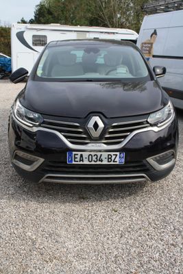 une voiture noire garée sur un parking à côté d'une caravane
