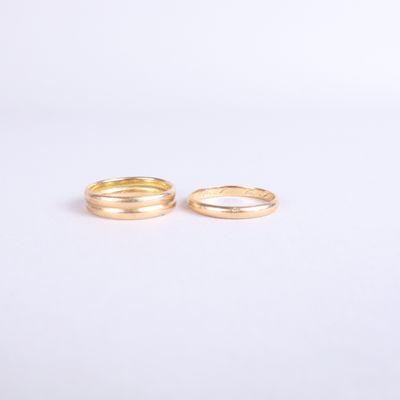 a pair of gold wedding rings on a white background