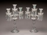 une paire de bougeoirs en verre transparent, ornés chacun de fleurs
