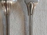deux cuillères et une fourchette en argent sur une table