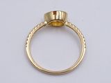 an image of a gold ring with a yellow stone in the center