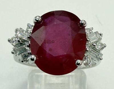 gros plan d'une bague avec une pierre rouge entourée de diamants blancs