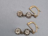 a pair of gold tone earrings with crystal stones