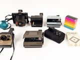 a lot of polaroid cameras sitting on a white surface