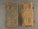 pair of old leather cases on a table with a gray background