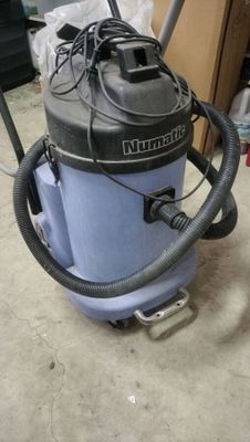 un aspirateur posé sur le sol de la pièce
