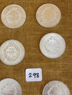 six types de pièces différents posés sur une table, accompagnés d'une étiquette de prix