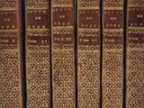 les dos des vieux livres sont alignés sur une étagère