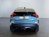 the rear end of a blue car in a white room