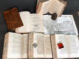 several open books sitting on top of a table next to a candle