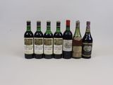 plusieurs bouteilles de vin sont alignées sur une surface blanche