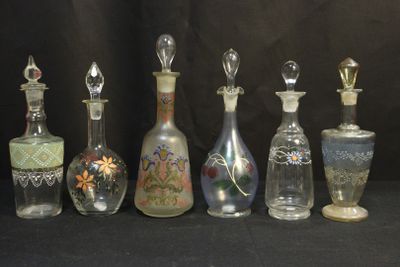 sept bouteilles en verre ornées de motifs différents sur fond noir