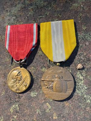 two medals sitting on top of a table next to each other