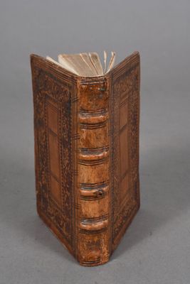 Un vieux livre est posé sur une table, sur fond gris.