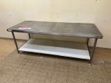 a metal table with a shelf on it in a room
