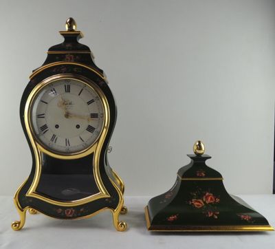 une horloge noire et dorée posée à côté d'une autre horloge noire et dorée