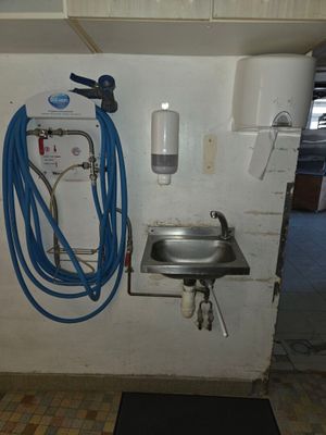 une photo d'une salle de bains avec un lavabo et des tuyaux fixés au mur
