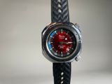 un gros plan d'une montre-bracelet au cadran rouge
