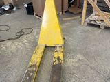 a fork lifter sitting on the ground in a warehouse