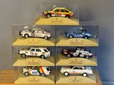 six different model cars in a display case on a table