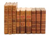 plusieurs vieux livres sont alignés sur une surface blanche