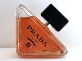 un petit flacon de parfum posé sur une surface blanche