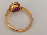 a close up of a gold ring with a pink stone