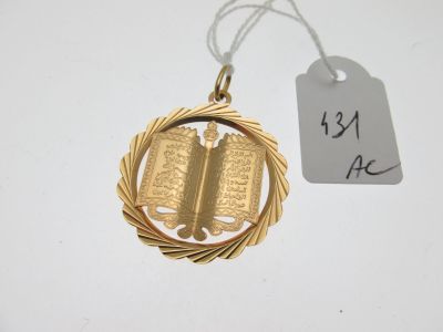 une médaille d'or sur laquelle est posé un livre et une étiquette de prix