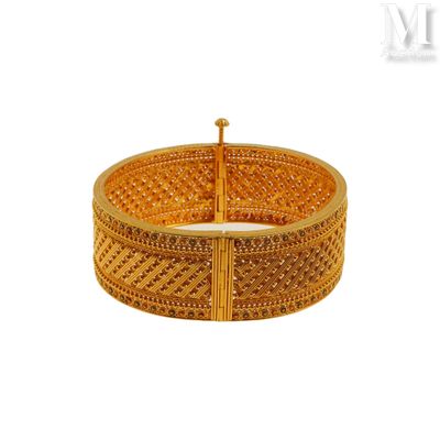 gros plan d'un bracelet en or sur fond blanc