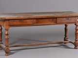 une vieille table en bois surmontée de deux tiroirs
