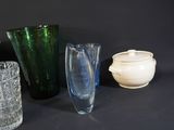 several different colored glass vases are lined up on a black surface