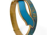 une image représentant une bague bleue et dorée ornée d'une vague