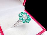 an image of a diamond and emerald ring in a red box