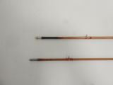 two old fishing rods on a white surface with a white background