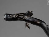 a close up of a walking stick with a bird on it