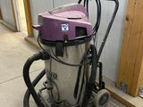 a vacuum that is sitting on the floor next to a wall