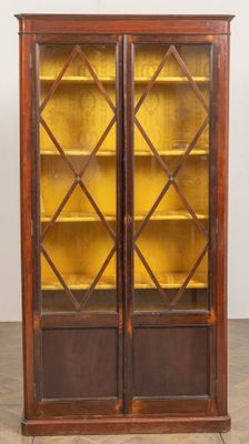 une bibliothèque en bois avec deux portes vitrées et deux étagères