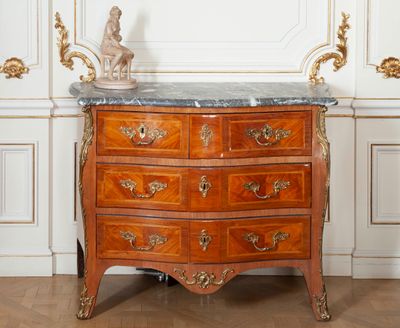 a marble top chest of drawers in the middle of a room