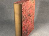 an old book sitting on top of a table next to a gray surface