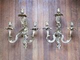 two wall sconces that are on a wooden floor