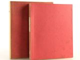 two red books sitting next to each other on a white surface