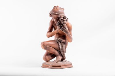 statue représentant une femme à genoux, les mains sur le visage