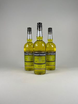 trois bouteilles de liqueur de citron posées sur une surface blanche