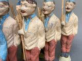 five ceramic figurines of men with hats and canes