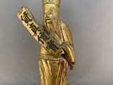 une image représentant une statue en or d'un homme tenant une batte de baseball